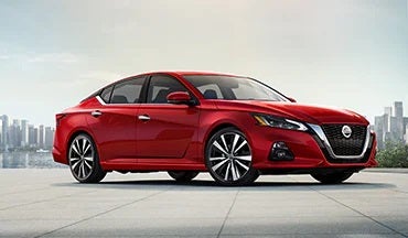2023 Nissan Altima in red with city in background illustrating last year's 2022 model in Mitchell Nissan in Enterprise AL